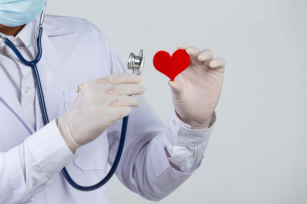World diabetes day;docter holding stethoscope and red heart wooden shape